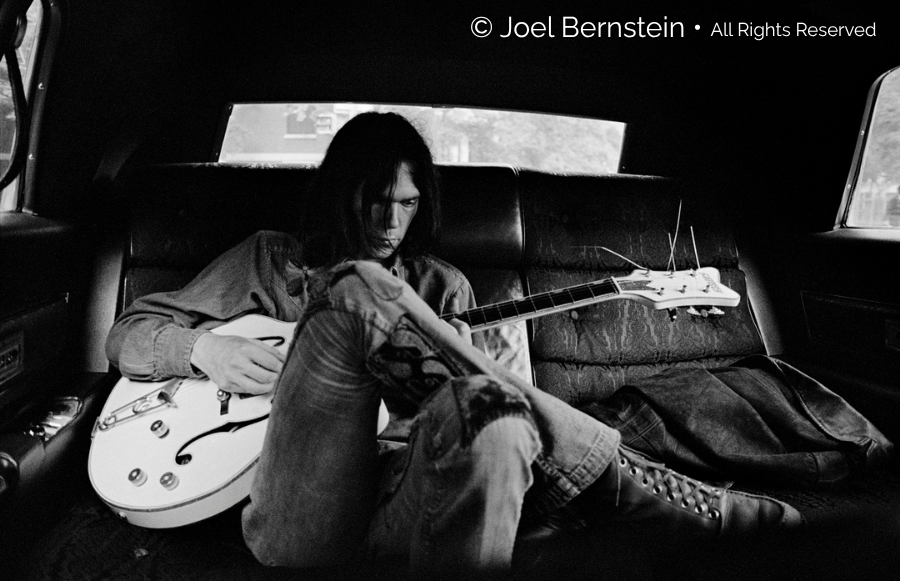 Joel Bernstein Photography - Neil Young in Limo with Guitar 1970